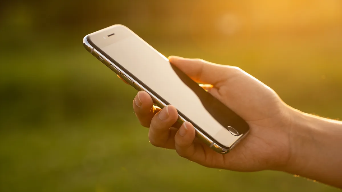 Mano sujetando un móvil premium, alternativa al Xiaomi 17 Ultra, al aire libre