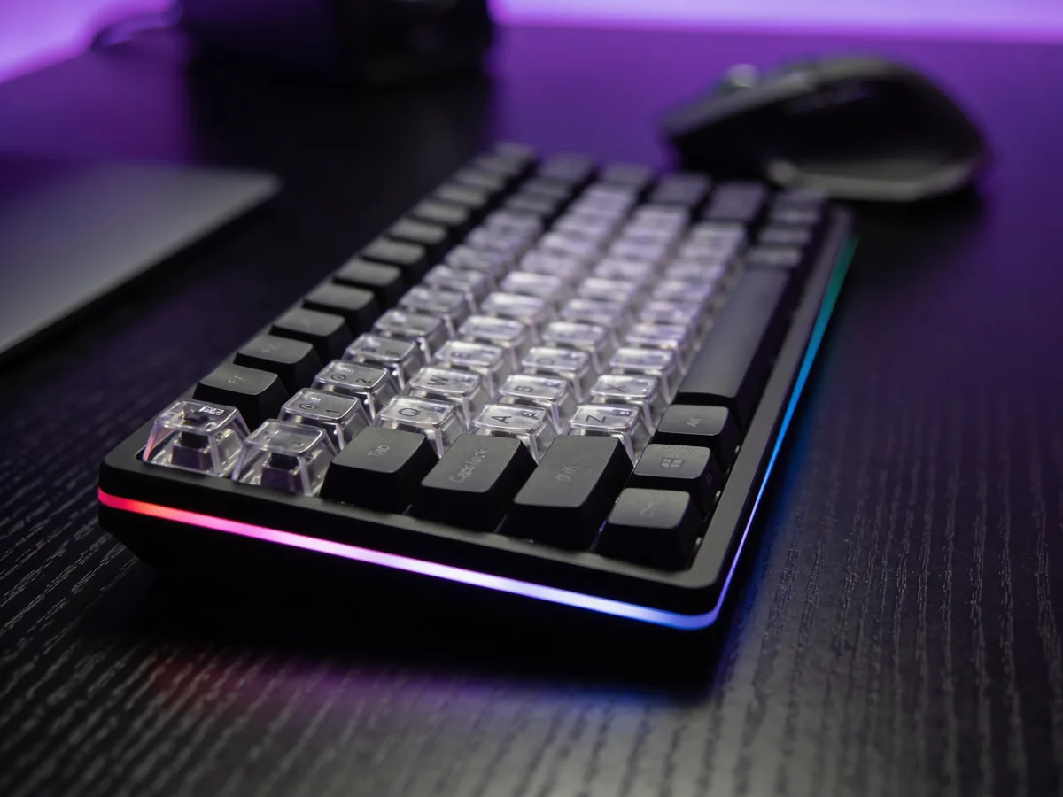 Teclado gaming inalambrico compacto con RGB junto a un raton gaming en un escritorio